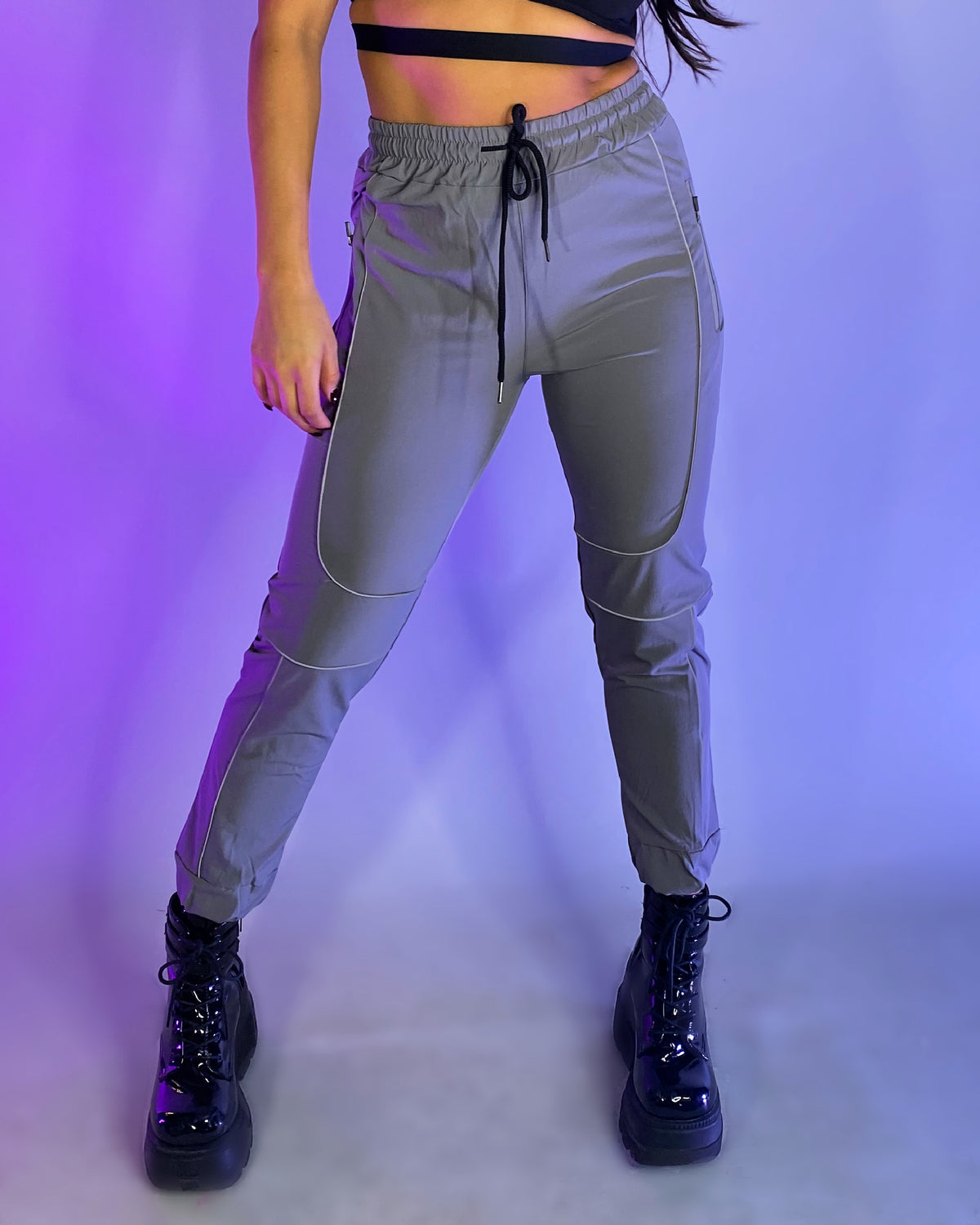Gray reflective joggers with drawstring waist, side pockets, and reflective bands on legs.