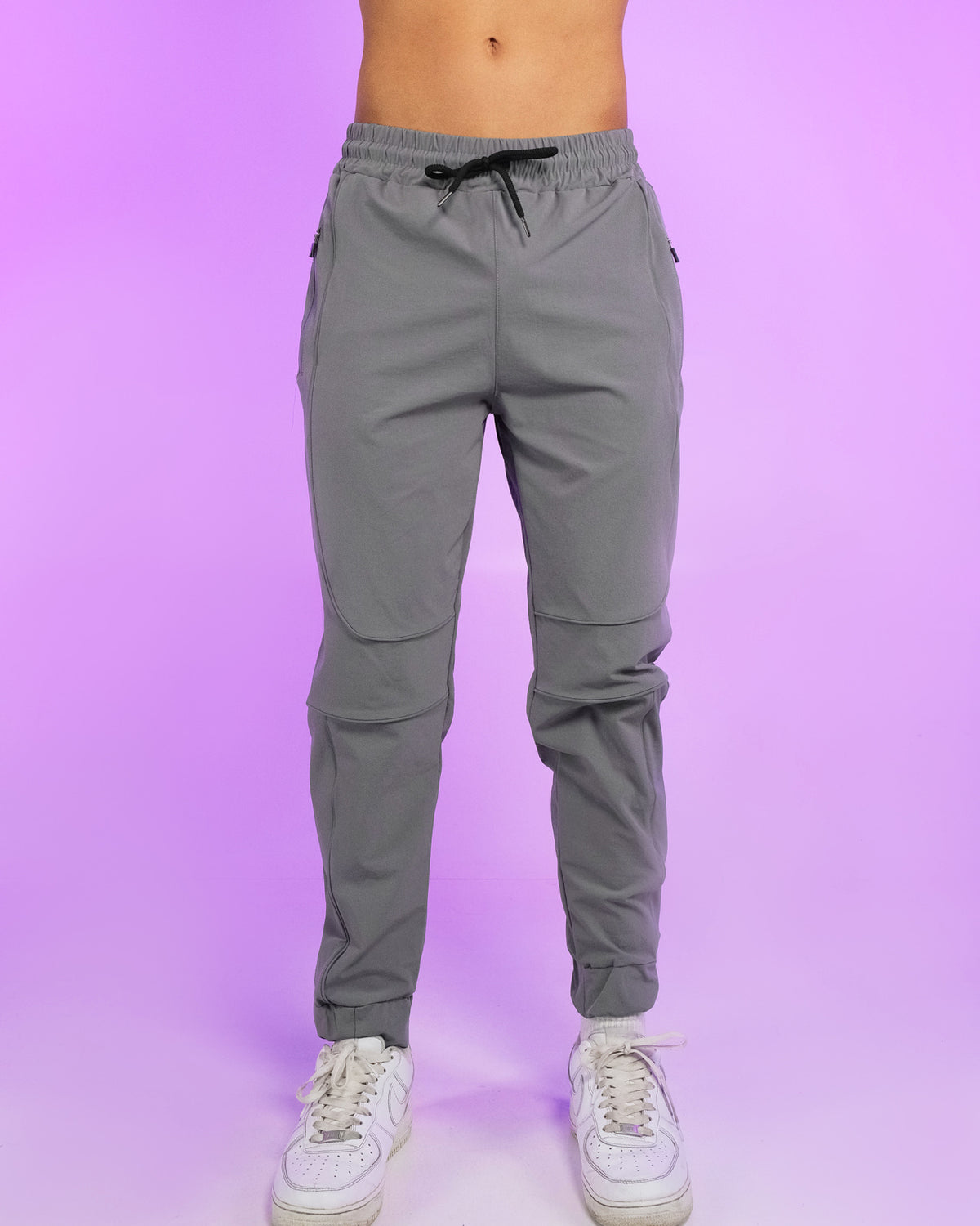 Gray reflective joggers with elastic waistband, black drawstring, tapered legs.