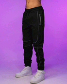 Black reflective joggers with side seam piping, relaxed tapered fit and drawstring waist