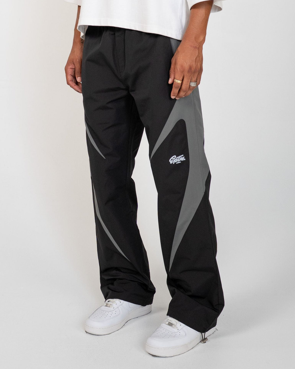 Black Blade Men's Reflective Pants, black wide-leg with gray blade panels, angled view on model
