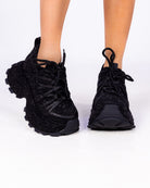 Black Crystal rhinestone wedge sneakers, all-black sparkle chunky sole, front view on feet