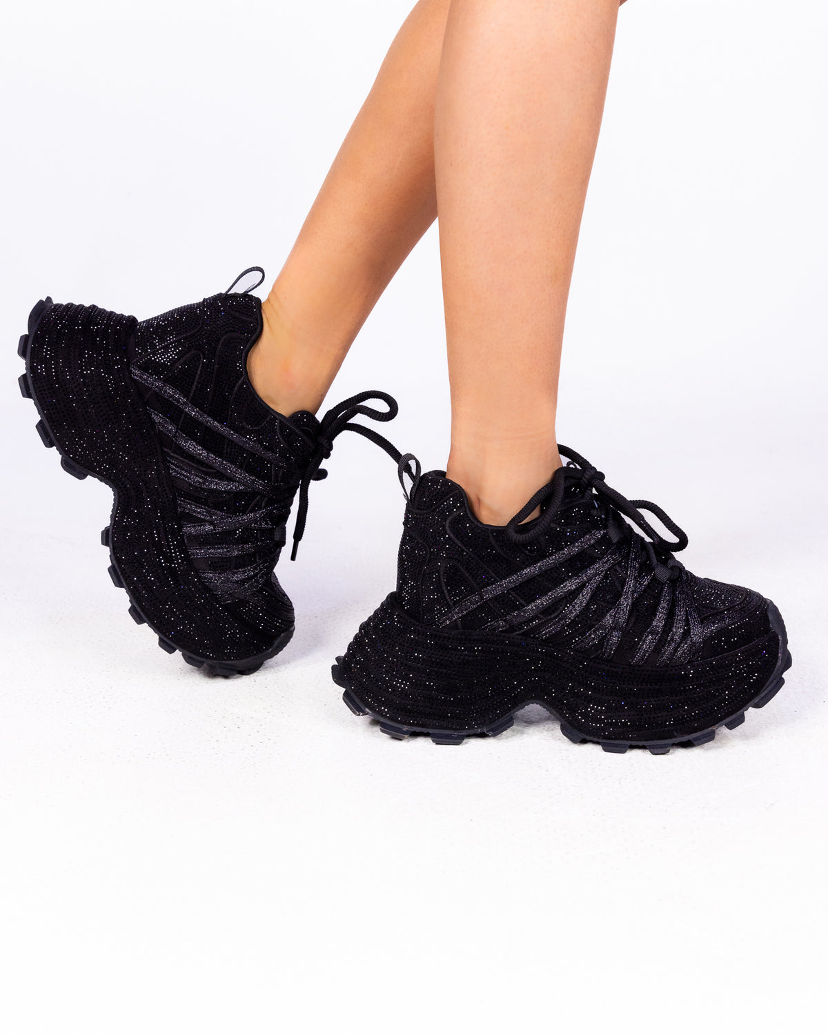 Black Crystal rhinestone wedge sneakers, all-black sparkle chunky sole, side view on feet