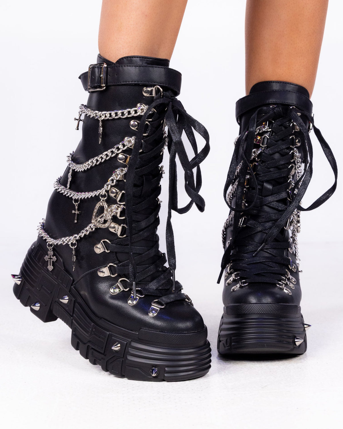 Black Holy Chains Edge mid-calf combat boots with silver chains, cross charms and lace-up front, front view