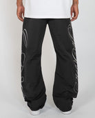 Black Monogram Men's Pants, black wide-leg with silver script monogram, back view on model