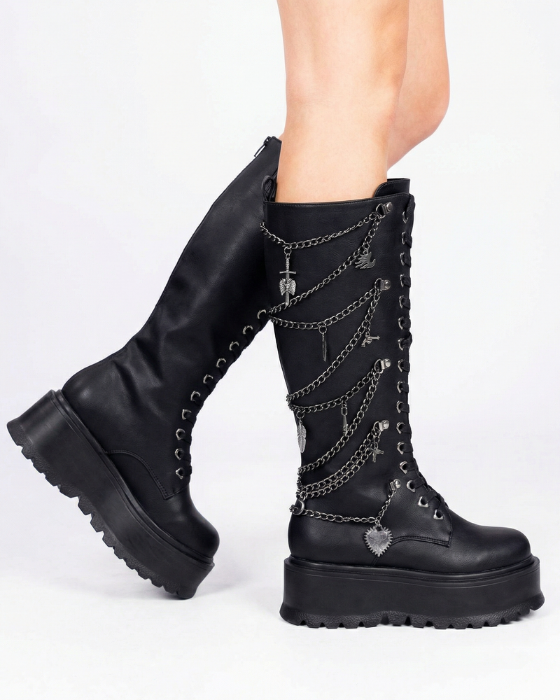 Black knee-high boots with chain details on a white background