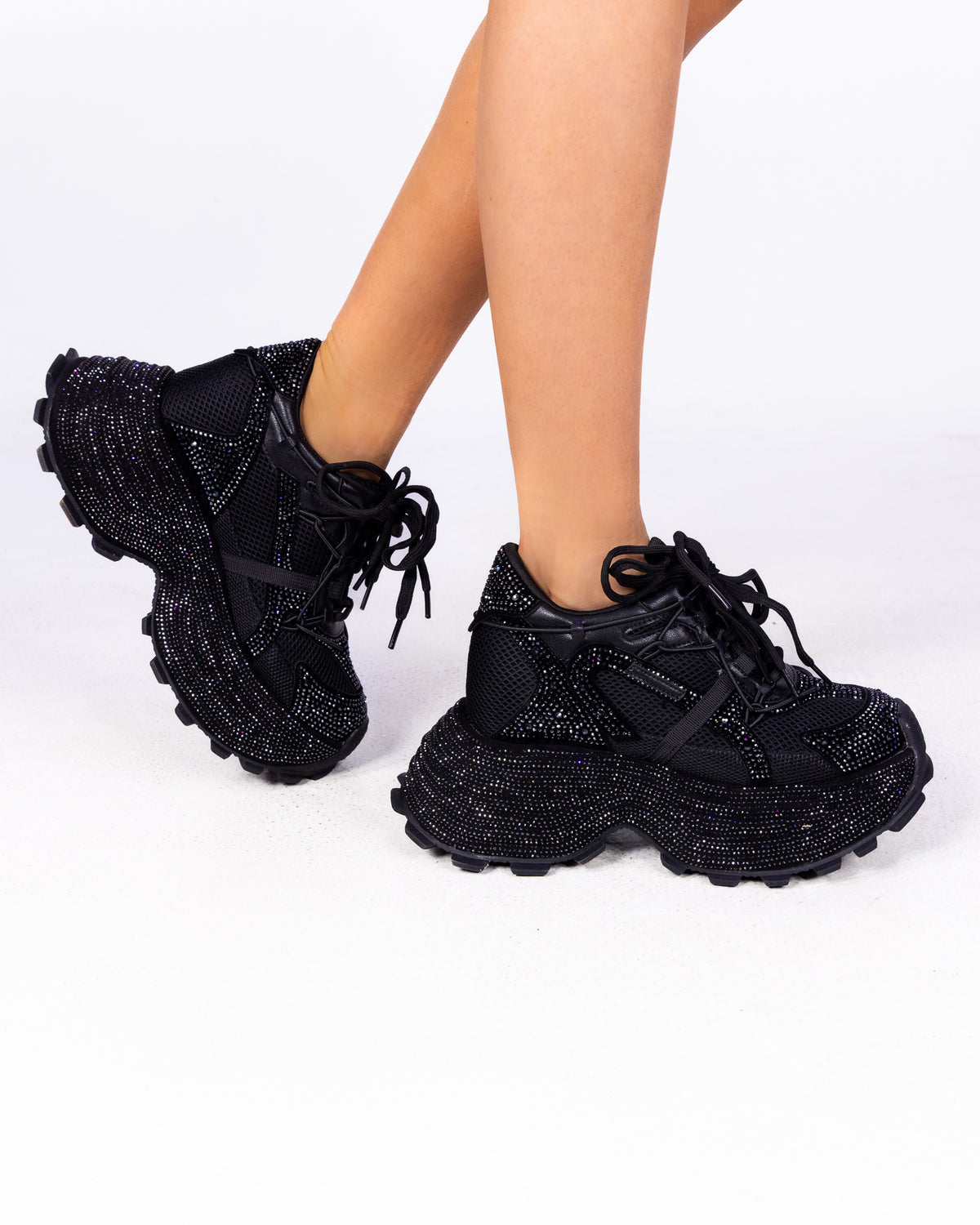 Midnight Sky black rhinestone wedge sneakers with chunky lug sole, side view on feet
