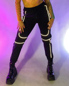 Close view of black reflective jogger legs with glowing trim and elastic ankle cuffs