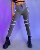 Gray reflective joggers with reflective stripes, drawstring waist, cuffed hems.