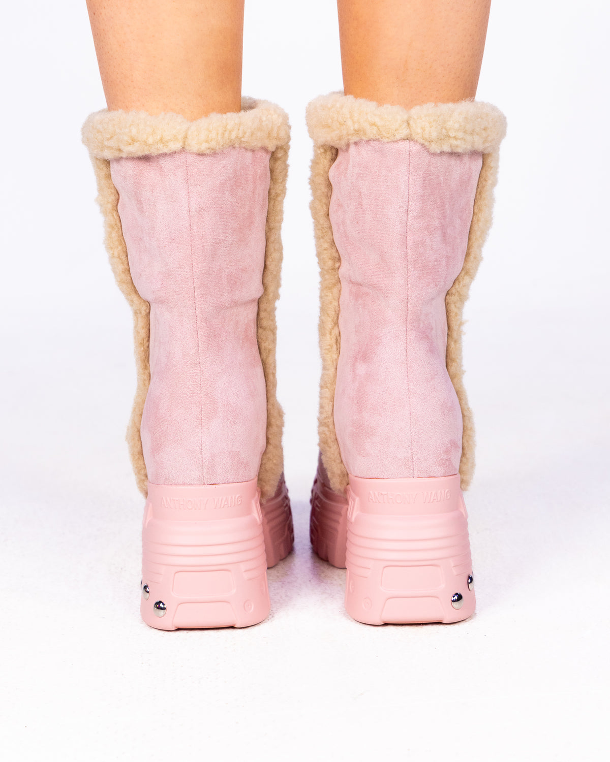 Pink Winter Glitch Edge platform mid-calf boots, pink suede with shearling trim, back view on feet