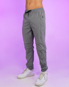 Gray reflective joggers with elastic waistband and drawstring, tapered ankle cuffs.