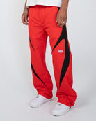 Red Blade Men's Pants, red wide-leg with black blade panels, angled view on model