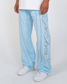 Sky Blue Monogram Men's Pants, light blue wide-leg with gray script monogram and piping, angled view on model