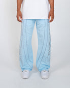 Sky Blue Monogram Men's Pants, light blue wide-leg with script monogram, front view on model