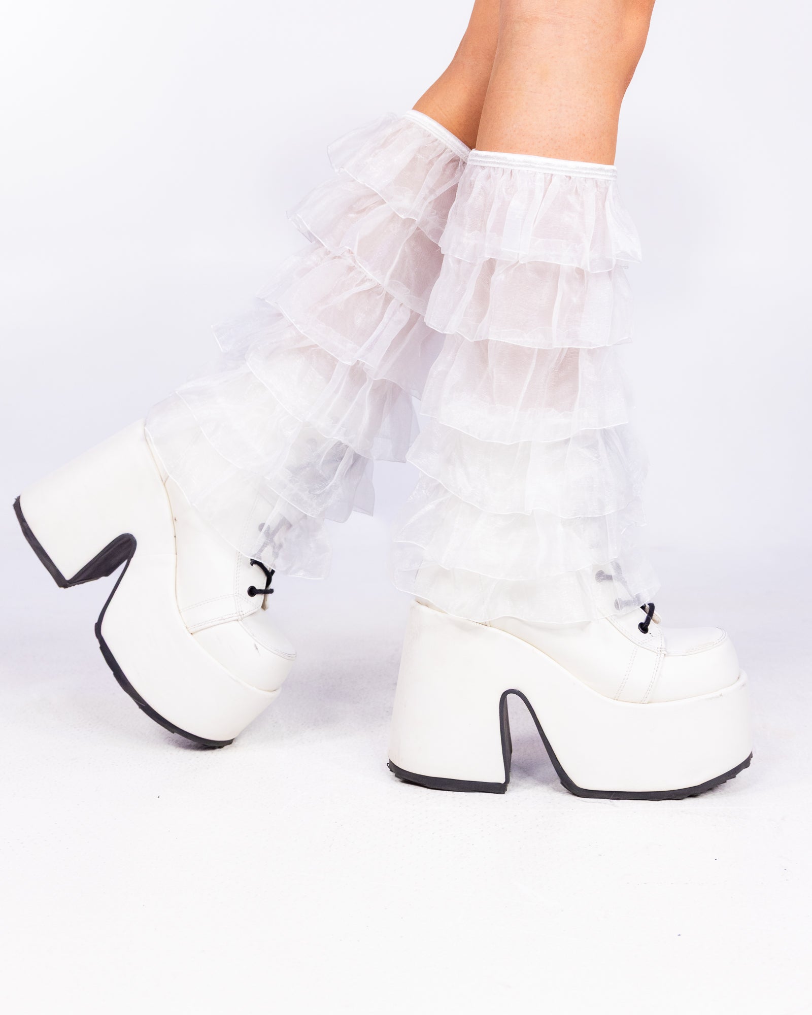 Sheer Luck white layered mesh ruffle leg warmers over white platform boots, side view