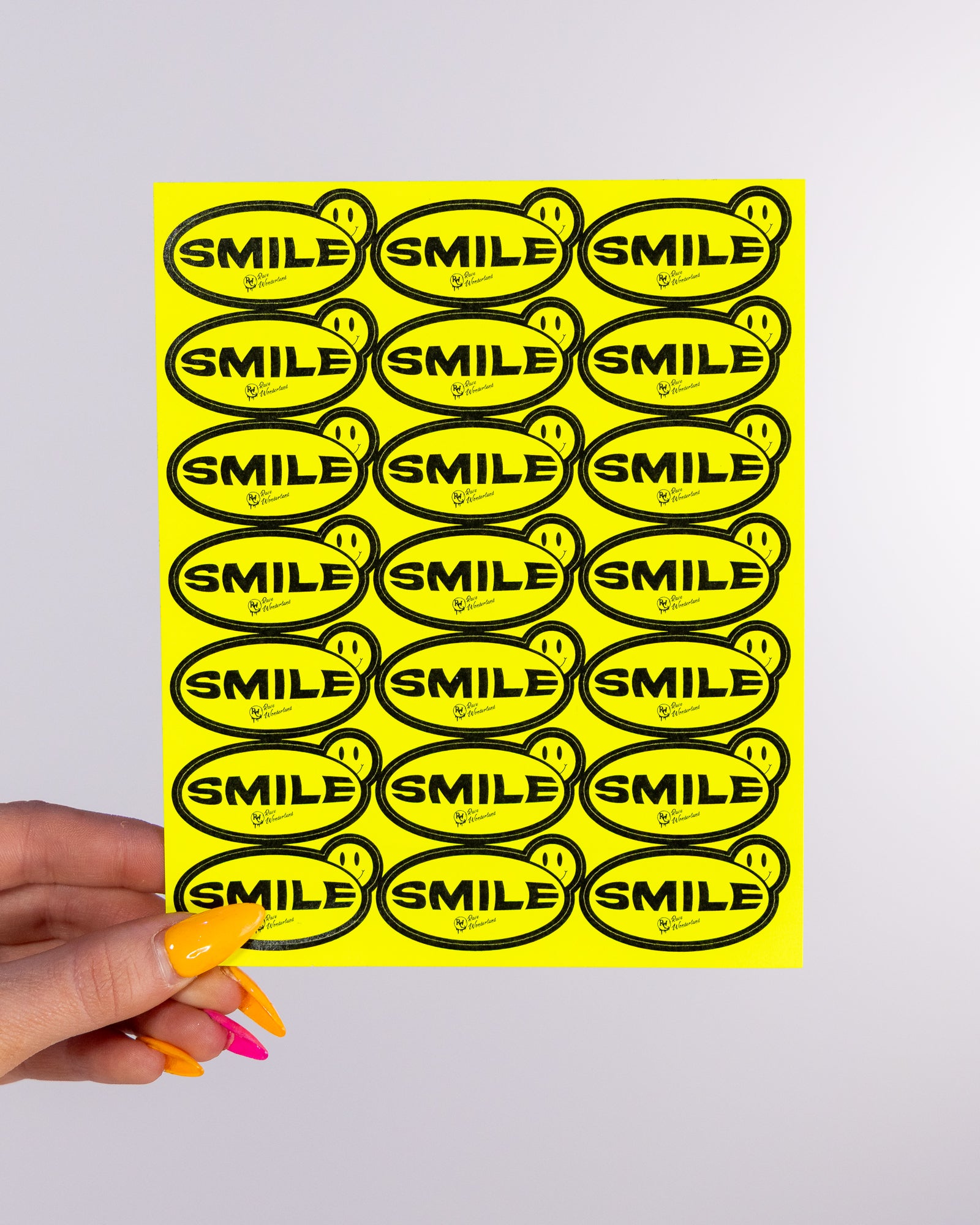 Yellow sticker sheet with multiple green “SMILE” oval smiley decals